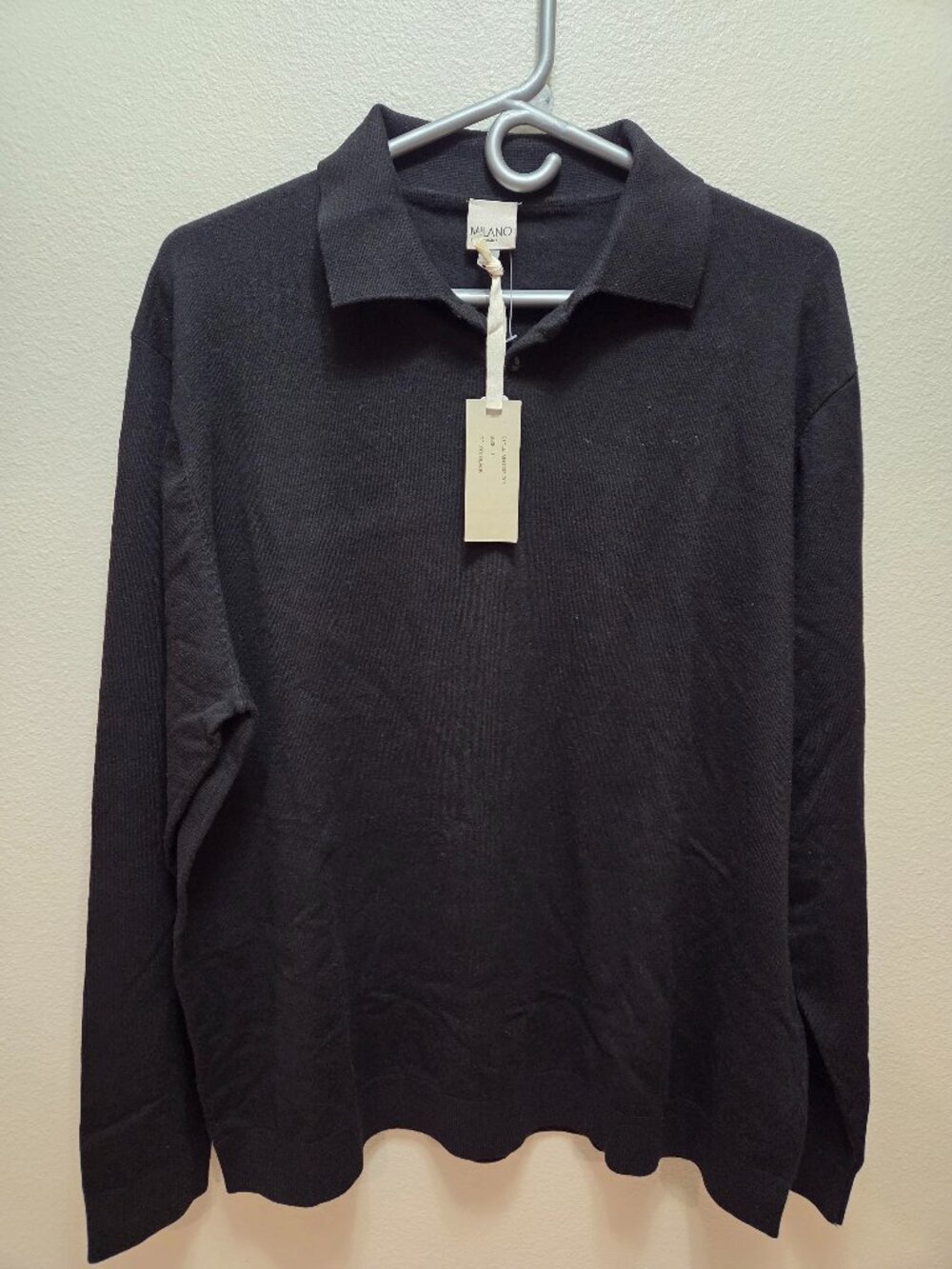 Black long-sleeve knit polo sweater with a collar and tag attached